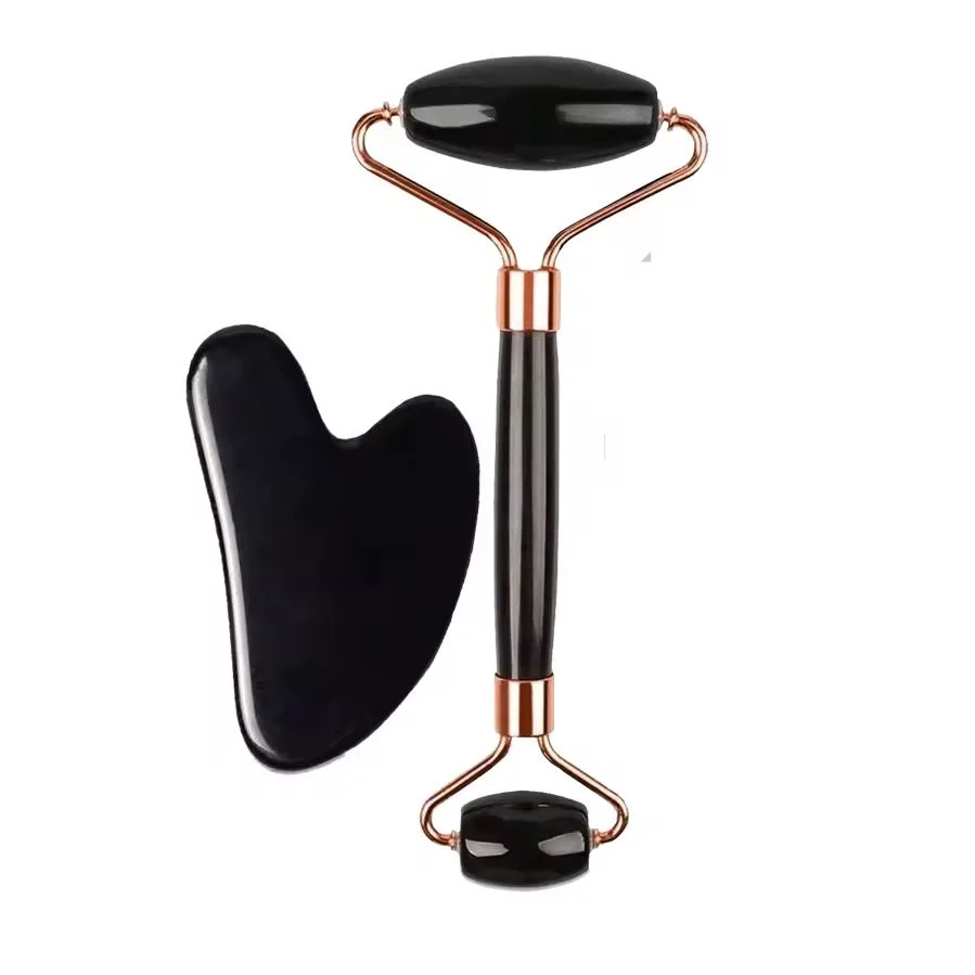 Black dual-ended face roller with gold-tone frame and black heart-shaped gua sha