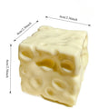 Pale yellow squishy cheese cube stress toy with holes, about 6 cm per side