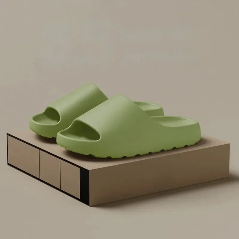 Pair of green thick-soled cloud slides on a display box